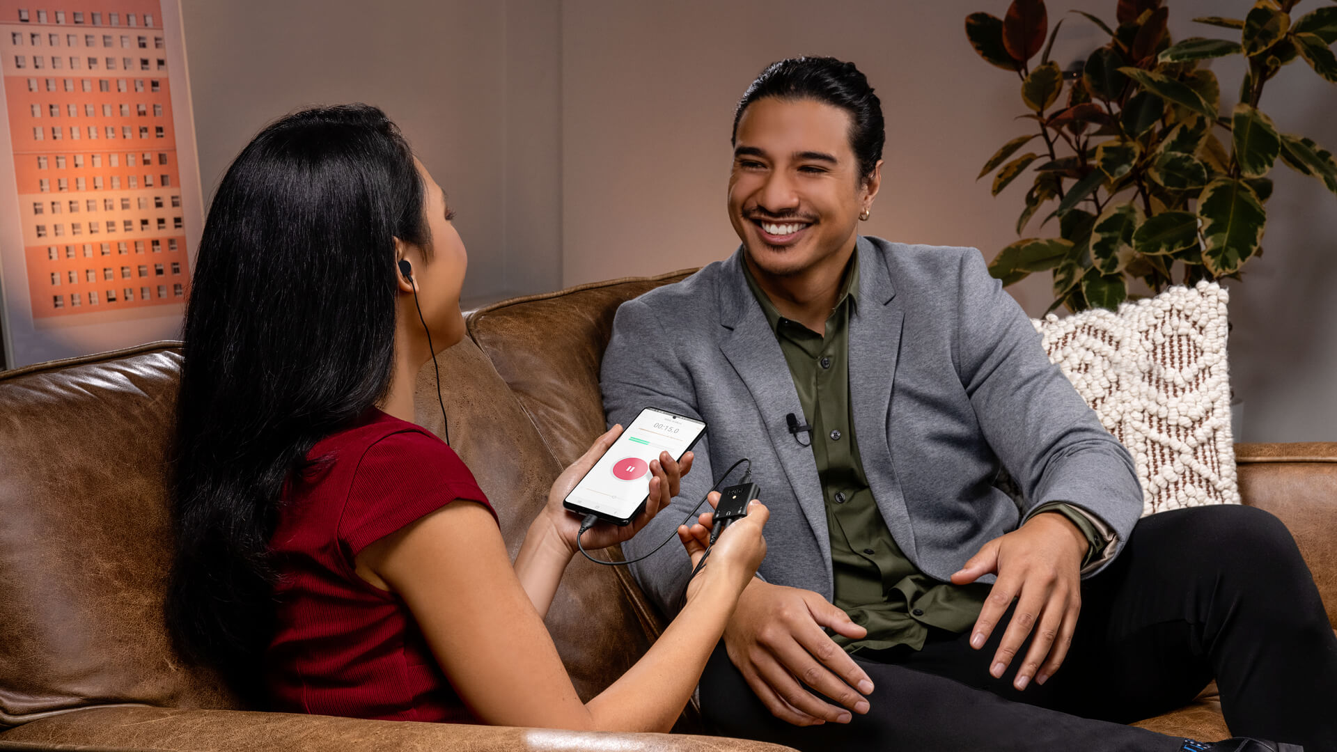 Man and woman doing couch interview via AI-Micro to mobile phone showing RØDE Reporter